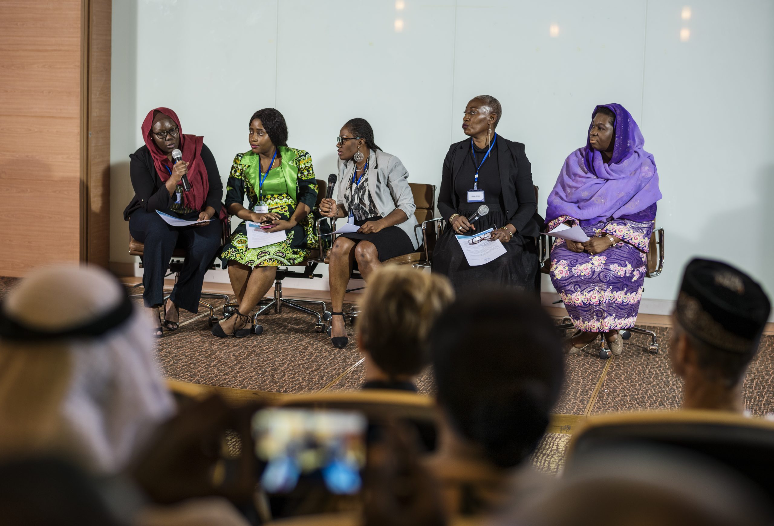 An African woman speaks on a panel with four other African women