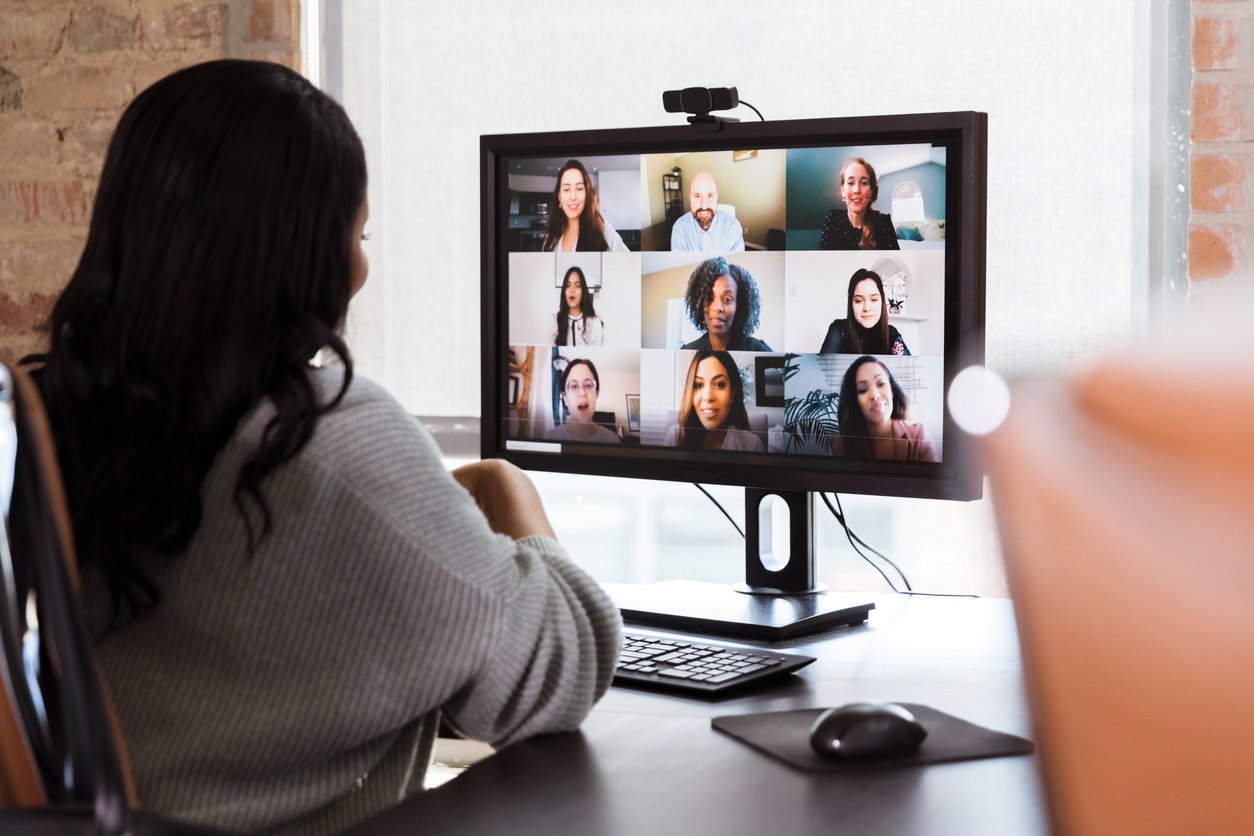 african-american woman looking at a web video conference with 9 colleagues