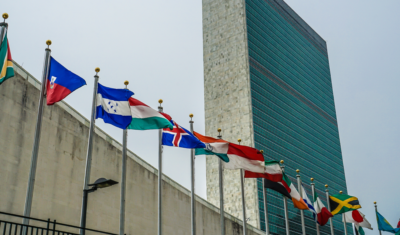 Picture of the UN headquarters with country flags at the entrance