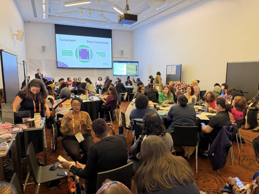 La foto de arriba muestra a un grupo diverso de mujeres y personas de géneros diversos, muchas de ellas con discapacidad, reunidas en la Preconferencia: "Leading Our Own Liberation: A Pre-Conference for Feminist Disabled Changemakers" (Líderes de Nuestra Propia Liberación: Una Preconferencia para Activistas Feministas con Discapacidad) en Women Deliver 2026.